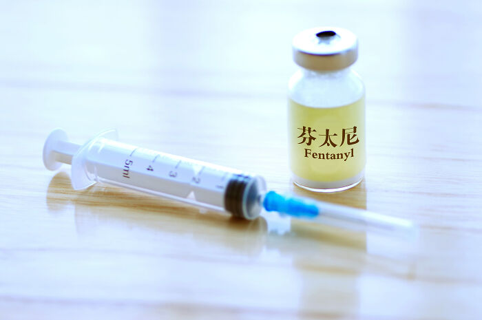 Vial labeled fentanyl and a syringe on a wooden surface, highlighting fentanyl supply issues related to Venezuela crackdown.
