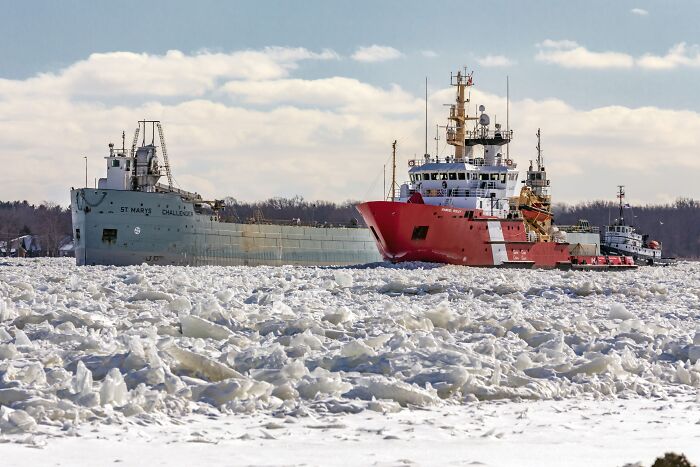 Coast Guard ships navigating through icy waters, highlighting Trump claims about redesigning ships for aesthetics.