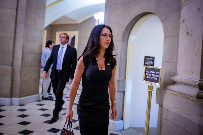 Lauren Boebert walking through a government building hallway amid rising pressure over Epstein files release.