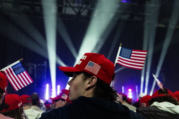 Supporters wearing red hats with American flags at a political event amid social media roasts involving Tomi Lahren.