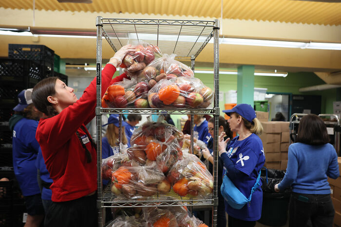 Volunteers packing fresh produce bags at a food bank amid fury over ignoring court order on SNAP benefits.