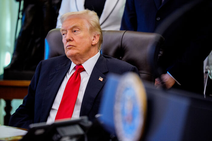Donald Trump seated at the White House, appearing tense during an on-air exchange with Fox host Laura Ingraham.
