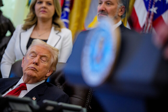 Former President Trump sitting with eyes closed during a formal event, with JD Vance mentioned in the background.