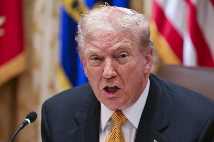 Donald Trump speaking emphatically at a formal event, discussing MAGA voter concerns and grocery prices.