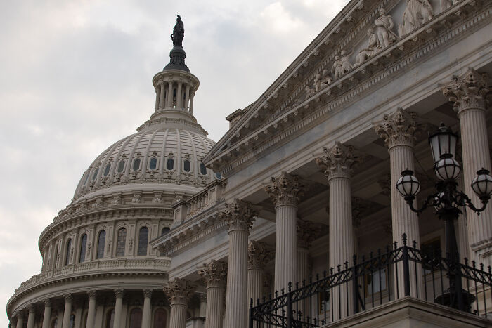 US Capitol building with cloudy sky, symbolizing Newsom criticizing Democrats for caving as senators reach shutdown deal.