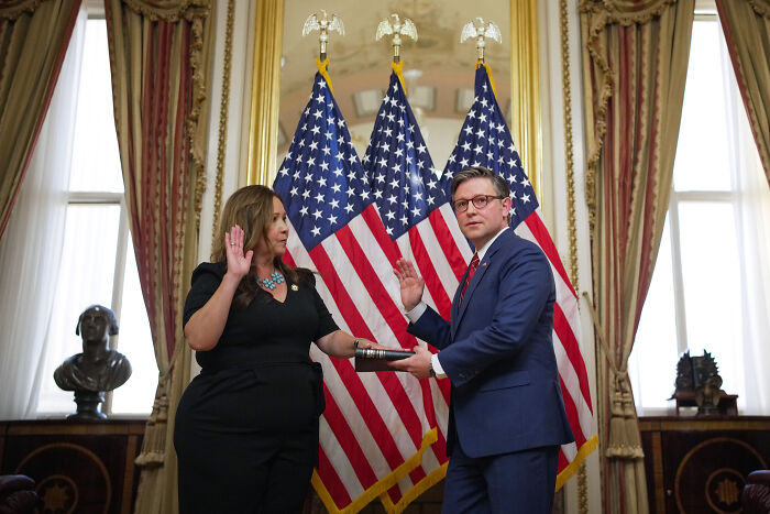 Lauren Boebert taking oath before American flags, related to Trump contact amid Epstein files release pressure.