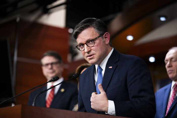 Man in suit and glasses speaking at podium during congressional session on Epstein files and related vote.