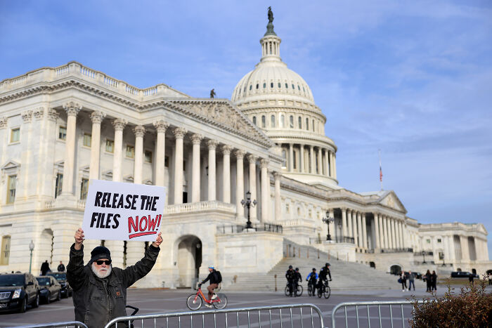 Protester outside Capitol holding release the files sign, referencing Trump and Congressional vote on Epstein files.