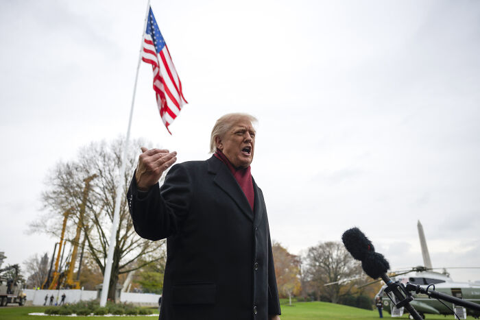 Donald Trump speaking outdoors near American flag, referencing his New York skyscraper battle and crass piggy insult.