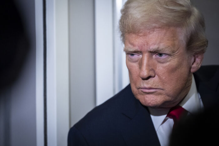 Donald Trump looking serious during an exchange with a reporter about Afghan shooter incident and insults.