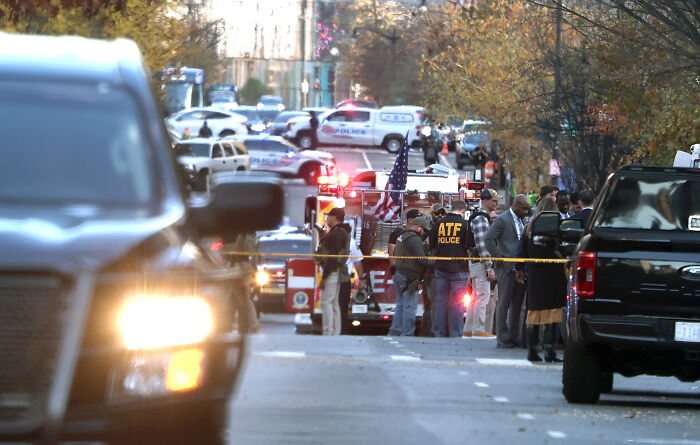 Law enforcement and ATF officers at a street crime scene responding to National Guard gunman incident in custody.