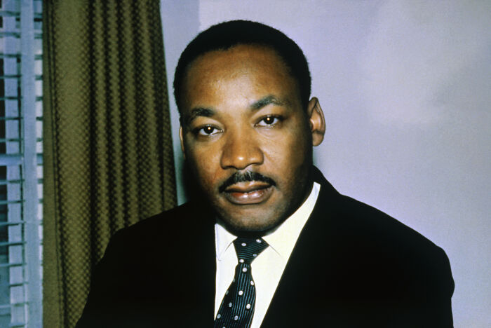 Portrait of Martin Luther King Jr. in a suit and tie, related to assassination files and CIA warehouse investigations.