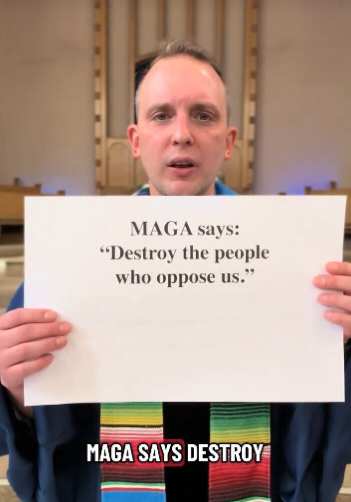Reverend holding sign opposing MAGA, using Bible verses in viral video to challenge conservative views indoors.