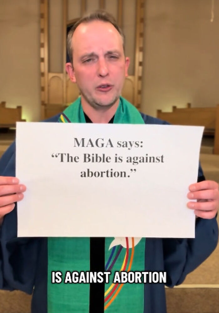Reverend opposing conservatives using Bible verses, holding sign about abortion in viral anti-MAGA message.