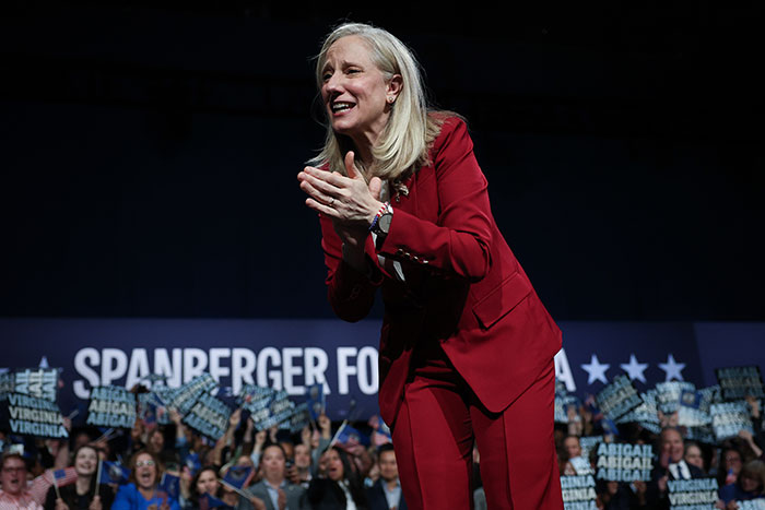 Female politician in red suit celebrates as Virginia turns blue delivering a heavy blow to Trump in a sweeping victory event