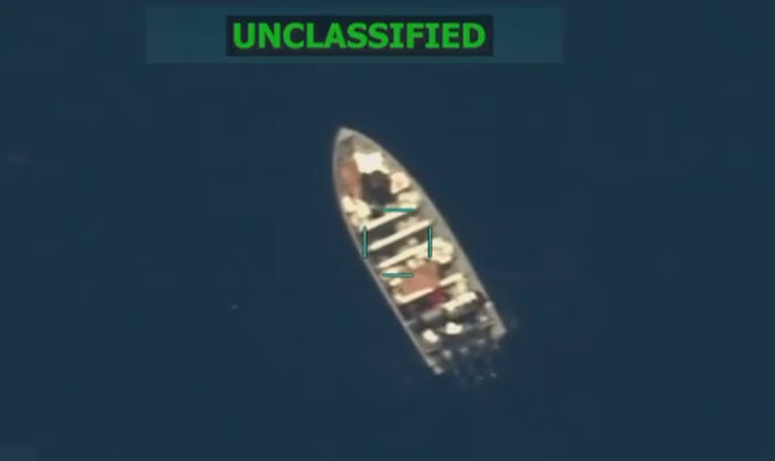 Aerial view of a small boat in open water linked to Pete Hegseth war crimes probe after alleged strike incident.