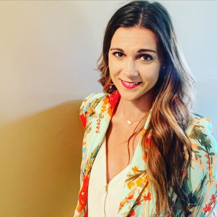 Female TV sports reporter smiling, wearing a floral jacket, representing beloved reporter found unresponsive at home.