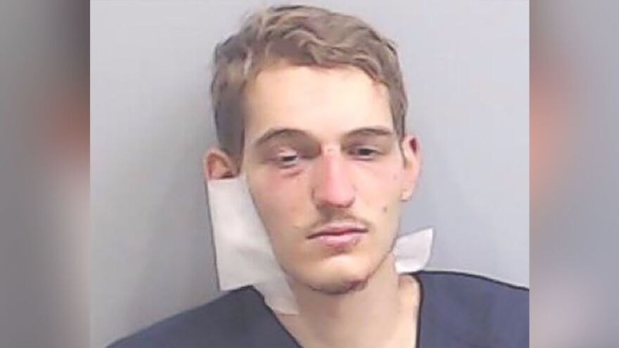 Mugshot of a young man linked to deceased parents who were brutally attacked found with toddler cuddling with them case.