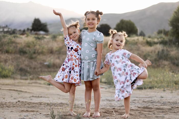 Three young girls smiling and posing outdoors in a field, unrelated to crimes that shocked the nation in 2025.