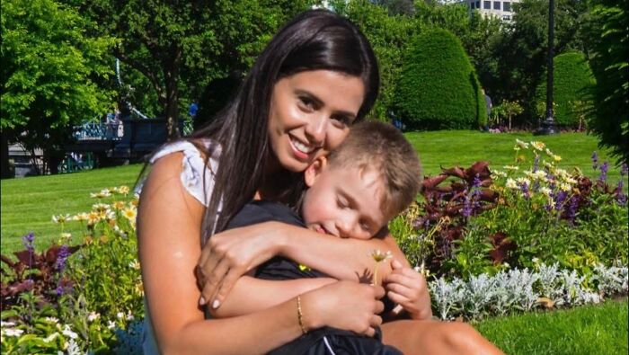 Woman hugging child in a garden setting illustrating Karoline Leavitt&rsquo;s detained family member and ICE custody family narrative.