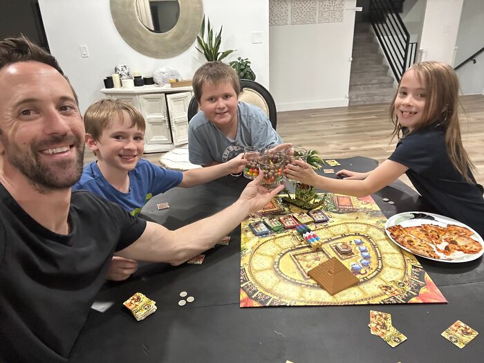 Family enjoying board game night together, highlighting mom&rsquo;s to-do list after alleged kids kidnapping to save from end days.