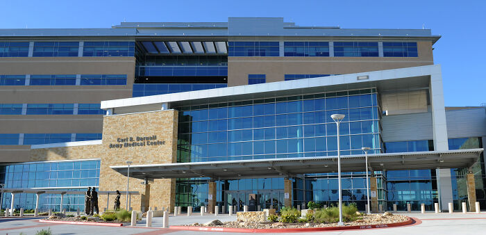 Modern army medical center building under clear blue sky representing army gynecologist and patient examinations context.