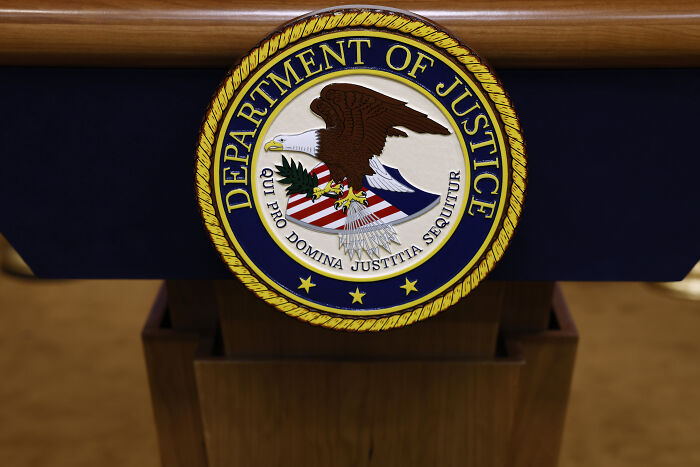 Seal of the Department of Justice displayed on a podium representing legal actions involving GPB Capital founder.