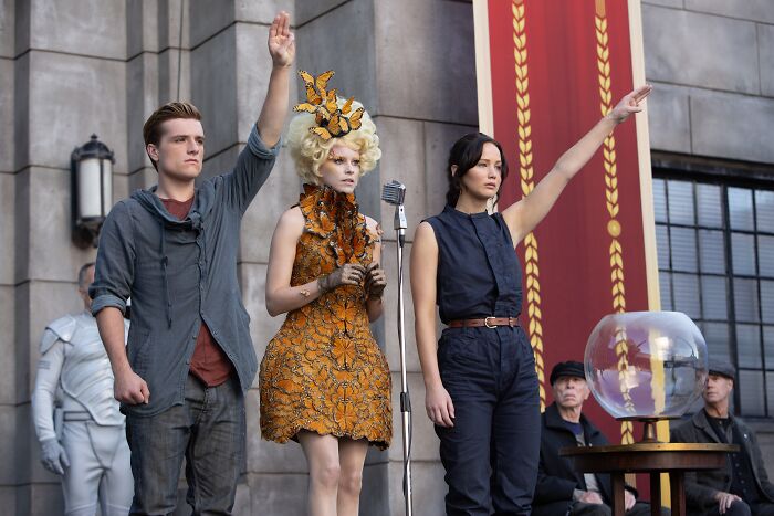 Two contestants from Patriot Games standing with raised hands during a contest event in front of a large banner.