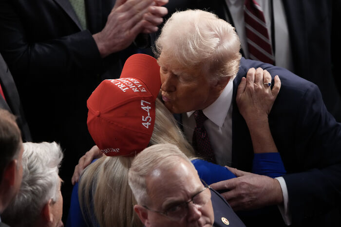 Donald Trump greeting supporter wearing red 45-47 hat, related to Trump shouted threat to reveal Epstein predators at MTG.