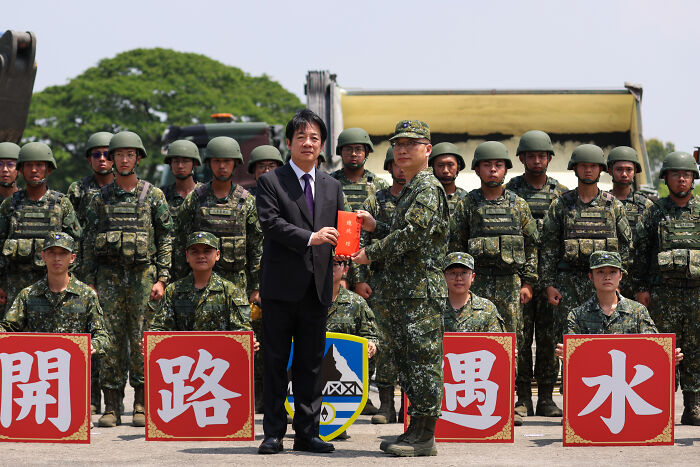 Military personnel in camouflage uniforms during a formal event symbolizing terrifying events closer to WW3 in 2025.