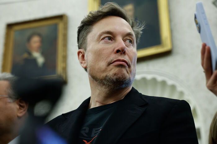 Elon Musk captured at an event with serious expression, highlighting Stephen Miller&rsquo;s wife working for Elon Musk.