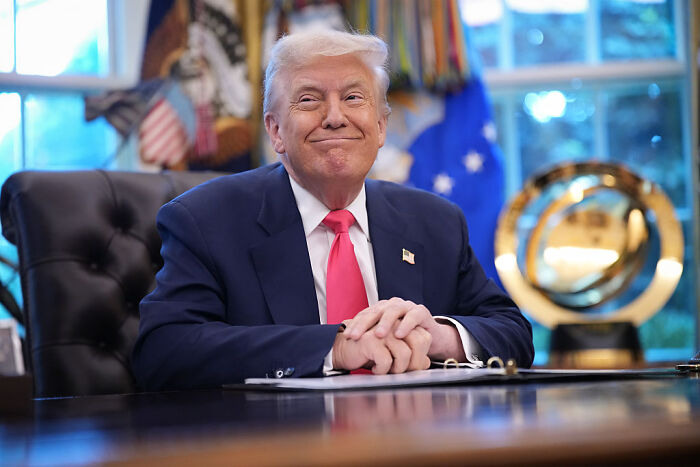 Donald Trump smiling at a desk in the White House, referencing his health compared to Barack Obama.