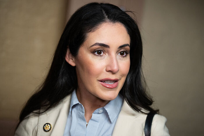 A confident MAGA woman speaking at an event, highlighting the MAGA women revolt against House Speaker Mike Johnson.