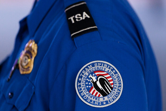 Close-up of TSA staff uniform badge and patch highlighting a hot mic moment with TSA staff feeling terrified at Kristi Noem event.