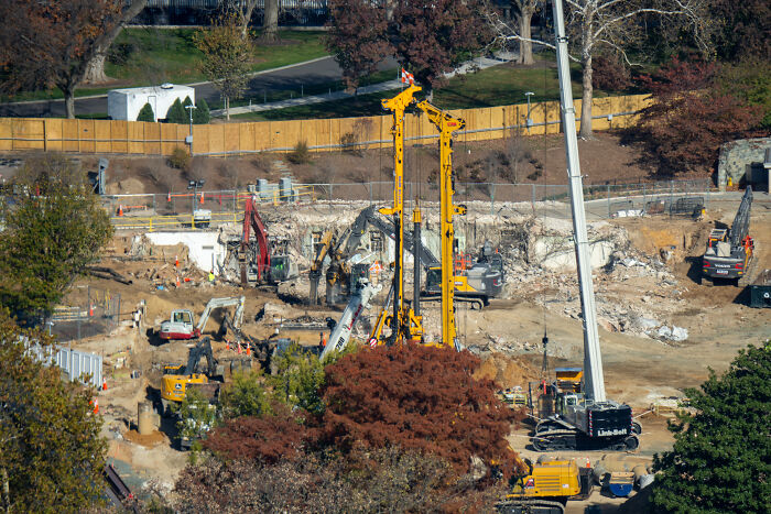 Construction site with heavy machinery and excavators amid autumn trees, unrelated to Trump&rsquo;s cabinet meeting wild moments.