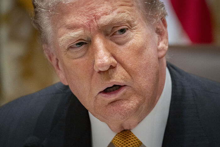 Donald Trump in a close-up, speaking with a serious expression, struggling to recall refusing to answer reporter&rsquo;s question.
