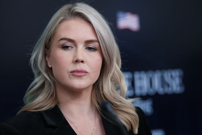 Karoline Leavitt looking serious at a press event, accused of lying about nephew&rsquo;s mom before ICE arrest.