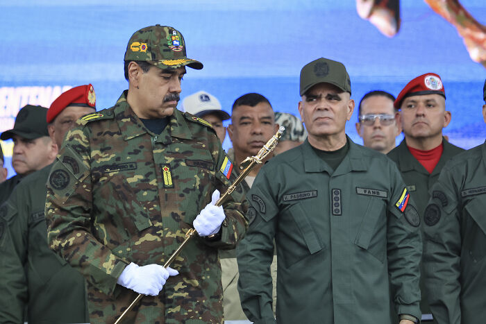 Military leaders in the Caribbean wearing uniforms during a formal event amid discussions on war crimes allegations.