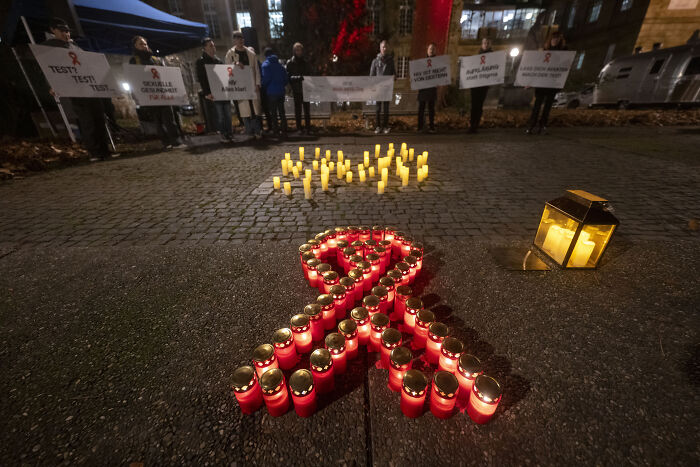 Red candles arranged in an AIDS ribbon at a World AIDS Day event protesting Trump Administration&rsquo;s decision.