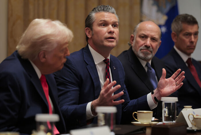 Trump&rsquo;s cabinet meeting with officials in suits, intense discussion capturing one man gesturing during a heated moment.