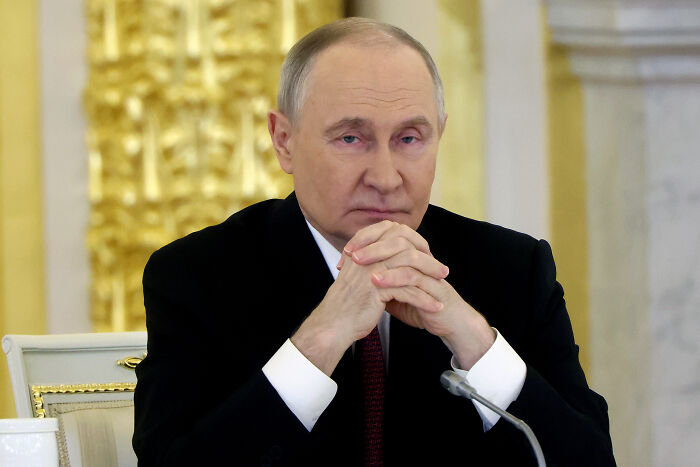 Russian leader in a formal setting, appearing contemplative amid reports of hungover Russians affecting Ukraine deep strike plans.