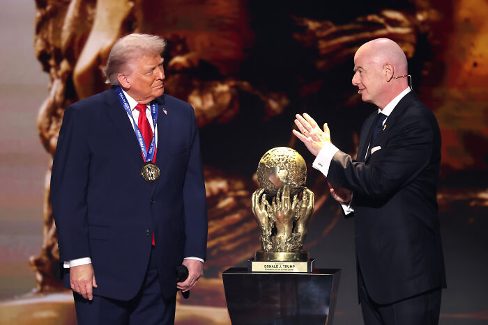 Donald Trump receiving a peace prize trophy on stage, sparking memes about his award participation moment.