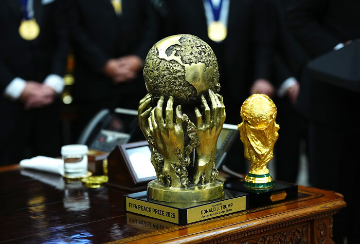 FIFA Peace Prize 2025 trophy on a wooden table linked to Trump&rsquo;s peace prize participation trophy memes.