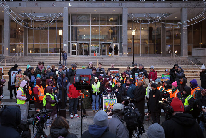 Kilmar Abrego Garcia speaking at a rally with supporters outside a government building, pledging to fight Trump admin.