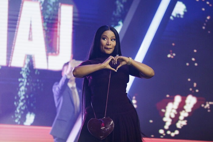 Nicki Minaj on stage making a heart shape with hands, linked to JD Vance and TPUSA event controversy.