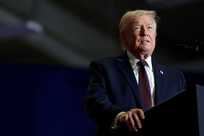 Donald Trump speaking at a podium, reacting to Epstein photo dump including big boy Clinton photos.