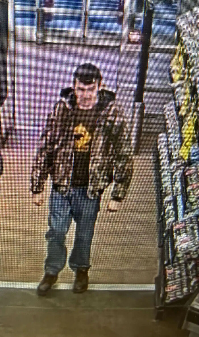 Teen arrested after attack on parents seen wearing camouflage jacket and jeans inside a store near snack racks.