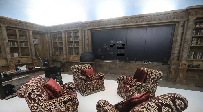 Luxurious island room with ornate armchairs, a large blackboard, and wooden bookshelves, linked to Epstein bank records discussion.