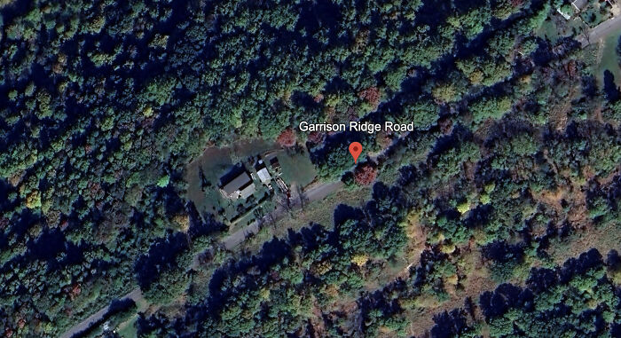 Aerial view of Garrison Ridge Road showing a rural home surrounded by dense forest where a teen was arrested after attack on parents.