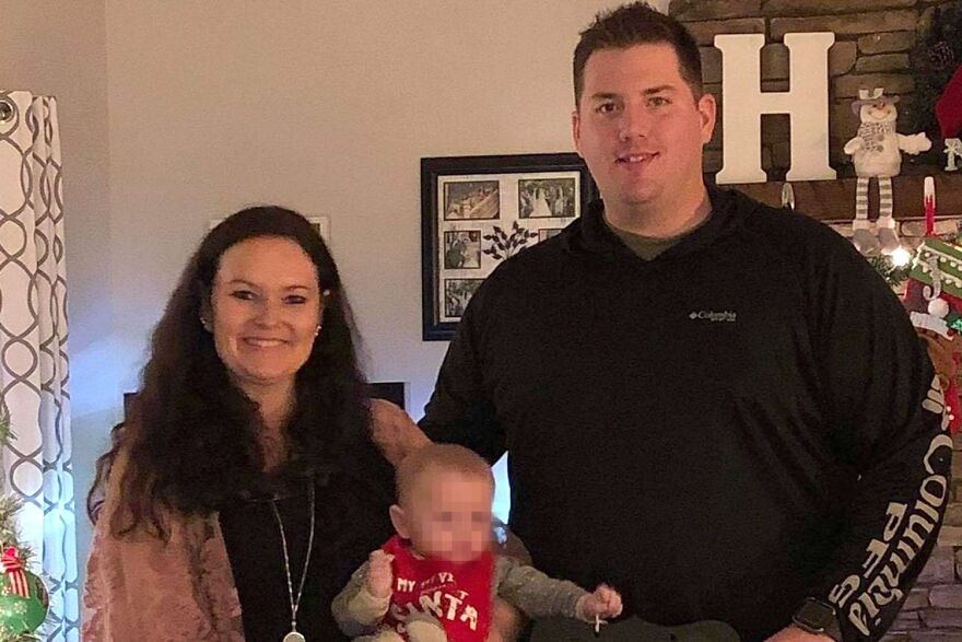 Couple smiling at home holding toddler, related to deceased parents brutally attacked found with toddler news.